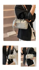 Detail of silver metallic Boston bag featuring smooth texture and a cute doll pendant