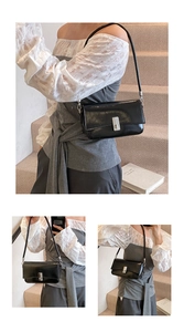 Detailed view of black oil wax leather shoulder bag with metallic silver buckle closure