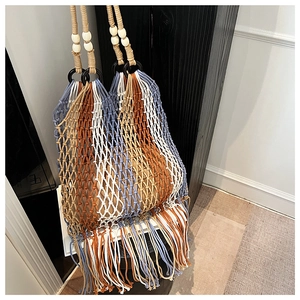 Detail of bohemian hand-woven tote bag with colorful cotton ropes and white wooden beads