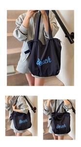 Detail view of navy nylon tote bag with light blue Beach text and drawstring closure