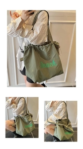 Detail view of olive green drawstring tote bag featuring green Beach letter print