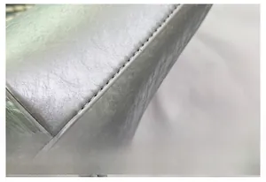 Macro detail of the fine stitching and metallic silver textured leather on the bucket bag