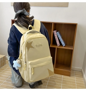 Détail du sac à dos scolaire crème avec patch étoile marron et pendentif en peluche