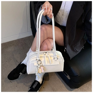 White leather Boston bag with long handles and cute ice cream charm on a model