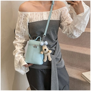 Light blue lychee pattern leather bucket bag with cute beige puppy plush keychain charm