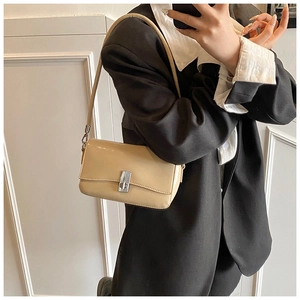 Detail of beige oil wax leather square bag with silver twist lock and slim shoulder strap