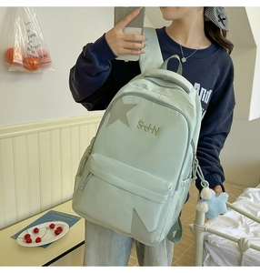Vue détaillée du sac à dos en nylon vert menthe avec patch étoile et broderie SUN