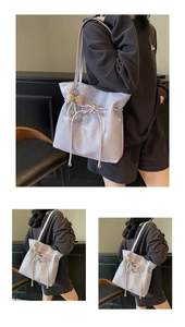 Détail du sac cabas violet clair avec cordon, pendentif nœud perlé et texture plissée chic