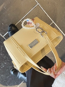 Schicke beige Eimertasche mit Lychee-Muster, Perlenkette und Silber-Logo-Plakette