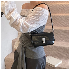 Detail of black oil wax leather handbag with silver metal buckle on elegant stairs