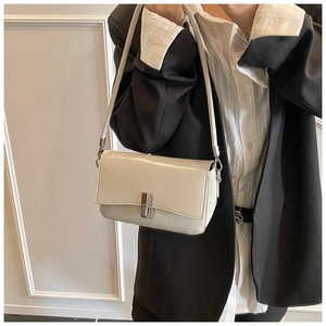 Detailed view of cream leather square crossbody bag with silver rotating metal lock clasp