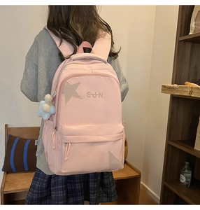 Détail du sac à dos en nylon rose clair avec écusson étoile et broderie S-JHN