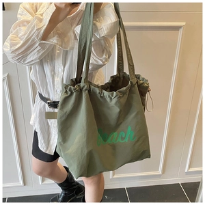 Detail of army green canvas tote bag with green Beach lettering and drawstring closure