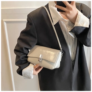 Mirror selfie showing stylish light gray oil wax leather shoulder bag with silver buckle
