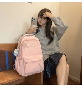 Détail du sac à dos d'école en nylon rose avec broderie étoile et breloque ours bleu