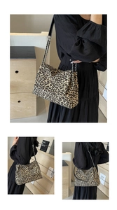 Detailed view of leopard print tote bag with metal chain strap on model's shoulder