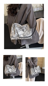 Close-up of ink landscape print canvas tote bag with chain strap and leather flap