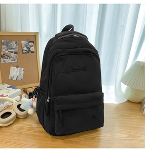 Vue détaillée d'un sac à dos noir en nylon avec broderie d'étoile et poignée respirante