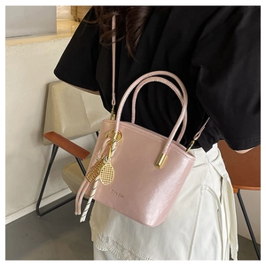 Pink PU leather bucket bag with a golden tennis racket charm and striped silk scarf