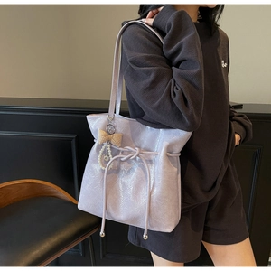 Détail du sac cabas en cuir lavande brillant avec cordon et pendentif en perles