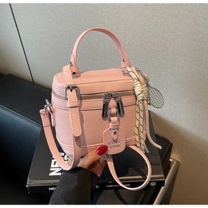 Détails du sac boîte rose en cuir grainé avec pendentif raquette de tennis et bandoulière