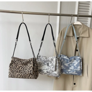 Close-up of three canvas tote bags featuring leopard, floral, and Toile de Jouy prints