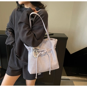 Dettaglio della borsa tote lavanda con coulisse decorativa e ciondolo con perla