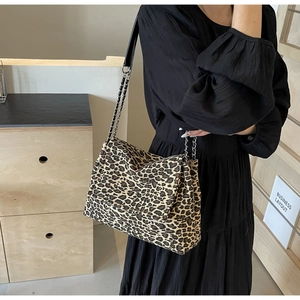 Detail view of the leopard print chain tote bag on a model showing large capacity and texture