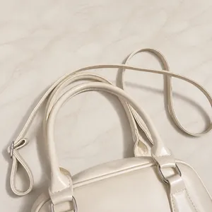 Detail of comfortable cream PU leather handles and metal hardware on bowling bag