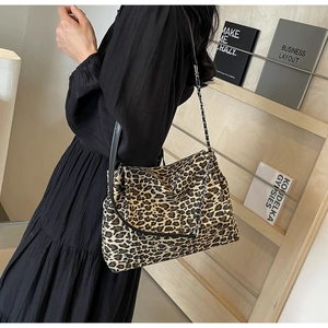 Detail of leopard print shoulder bag with gold chain strap and elegant flap closure design