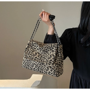 Detail of leopard print tote bag with silver metal chain strap and woven texture