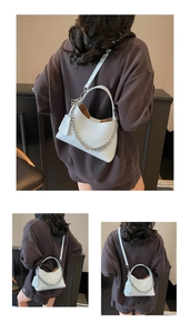Detail of light blue bucket bag with pebbled leather texture and silver chain strap
