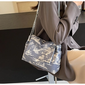 Close-up of Chinese landscape print tote bag with woven chain strap on a model