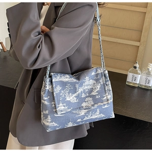 Detailed view of the Chinese landscape pattern and silver chain strap on the canvas bag