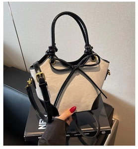 Détail du sac seau vintage avec un nœud noir et un fermoir en métal doré élégant