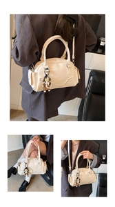 Detail of cream leather bowling bag with vintage stitching and cute bear charm accessory