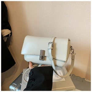 Detailed close-up of cream oil wax leather crossbody bag with silver rotating lock buckle