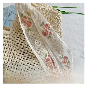 Detailed close-up of beige woven tote bag featuring floral lace scarf and mesh texture