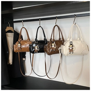 Detailed view of four vintage bowling bags with plush charms and decorative stitching