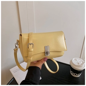 Close-up of light yellow oil wax leather crossbody bag featuring silver metallic turn lock