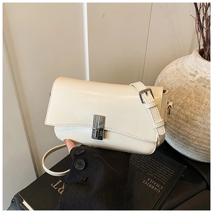Detail of off-white faux leather crossbody bag with silver rotating metal lock and strap