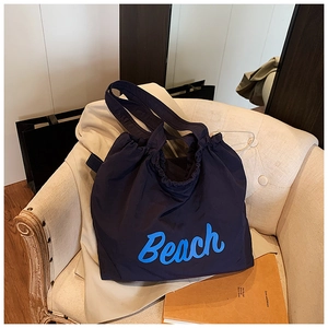 Detail of navy blue drawstring tote bag with Beach print on canvas fabric