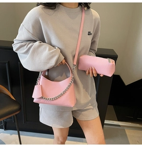 Detail view of pink lychee textured leather bucket bag set with silver chain and strap