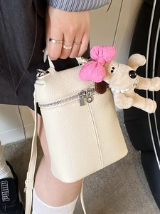 Chic beige lychee grain crossbody bucket bag with cute puppy plush charm for women