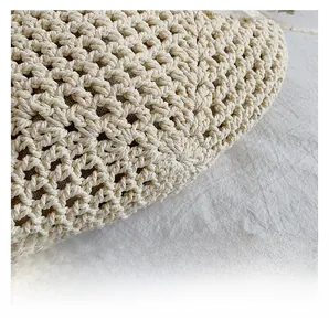 Macro shot of off-white hand-woven tote bag showing detailed crochet knit patterns