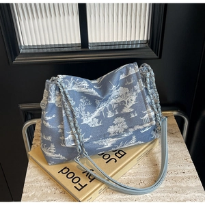 Detail of blue Toile de Jouy landscape print on tote bag with silver chain strap