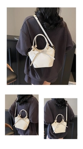 Détail du sac seau beige montrant le cordon à nœud et les ferrures dorées chic