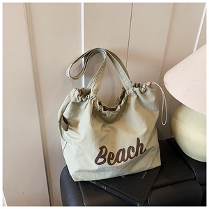 Detail view of light green tote bag with Beach print and functional drawstring closure