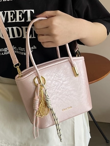Pink minimalist PU bucket bag with glossy crinkle texture and golden tennis racket charm