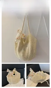 Detail of off-white hollow woven tote bag with a floral print scarf bow decoration